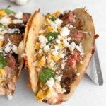 Carne asada tacos topped with street corn in taco holders