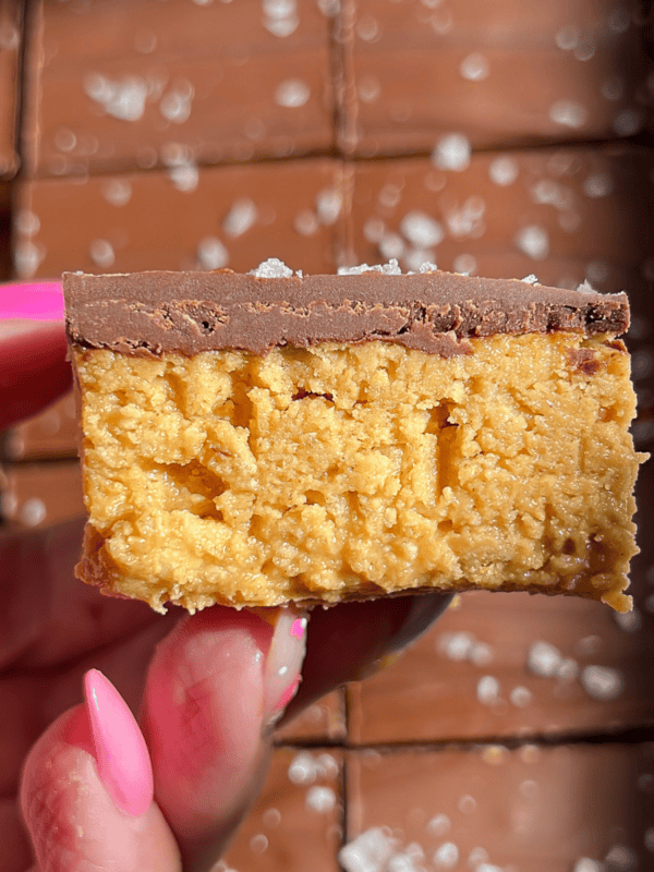 A hand holding a no-bake peanut butter bar