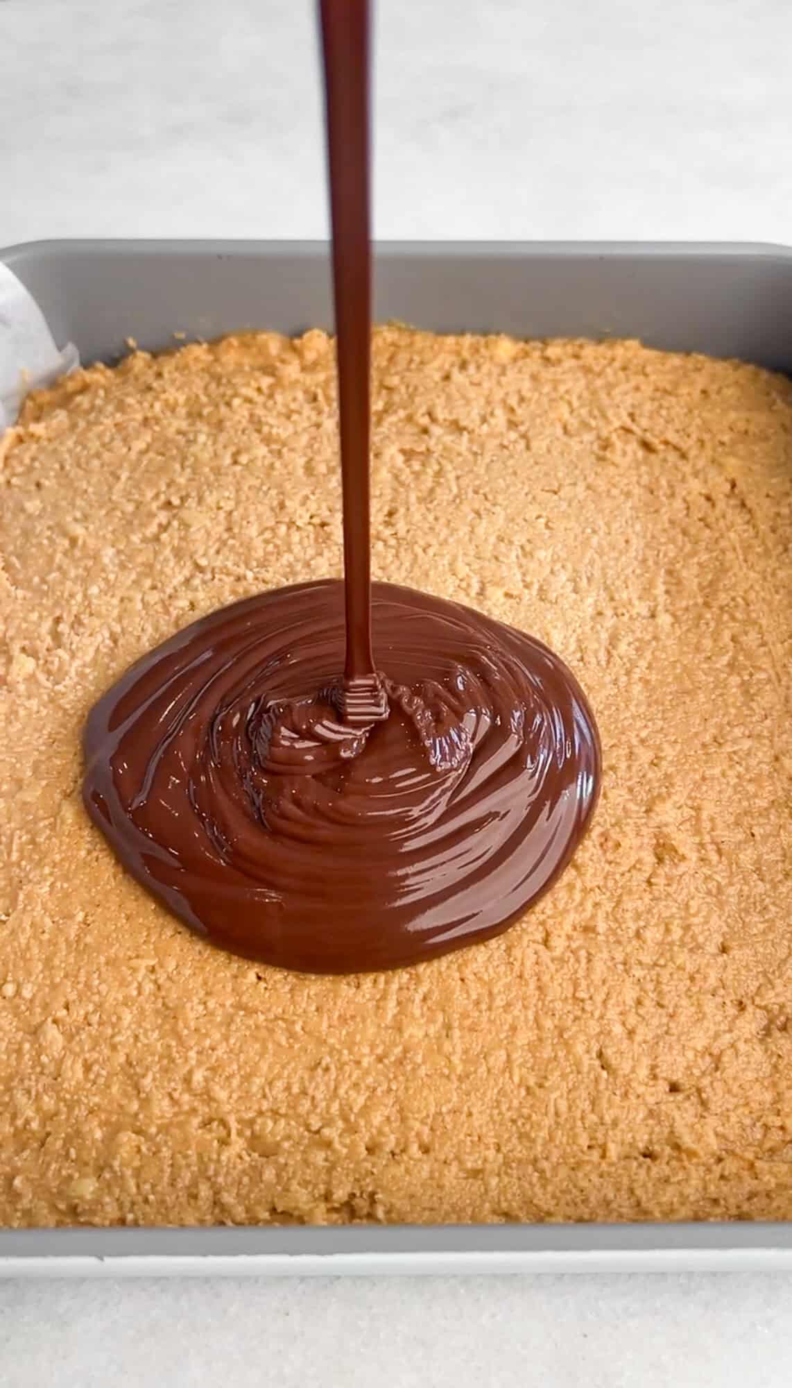 These no-bake peanut butter bars have a soft, sweet peanut butter base and a rich chocolate top with a sprinkle of flaky salt. Drizzling melted chocolate over the peanut butter layer in a pan