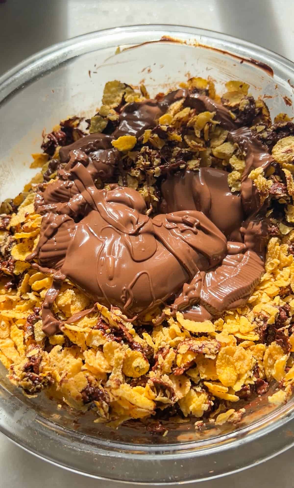 Melted chocolate and Nutella added to a bowl with cornflakes