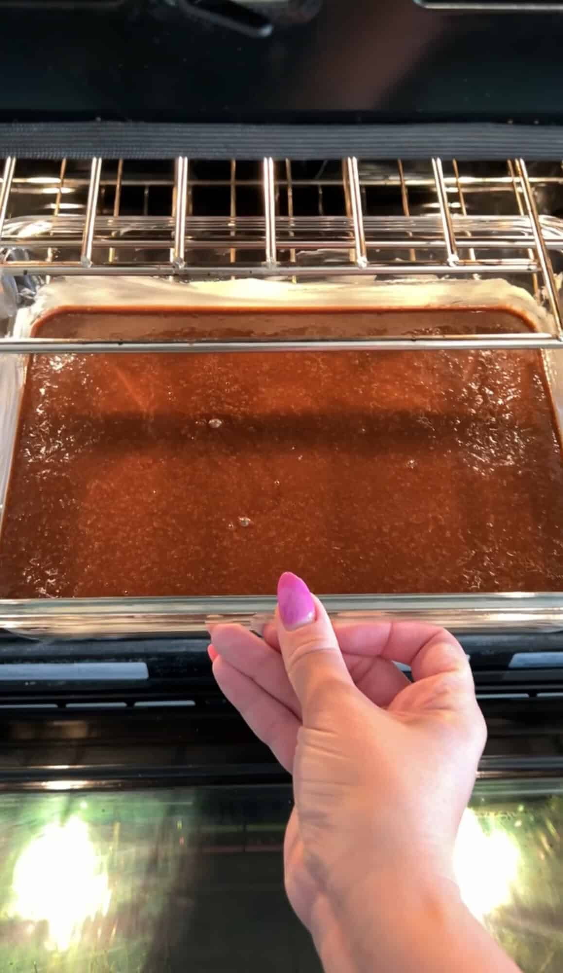 Placing a pan of chocolate cake batter in the oven