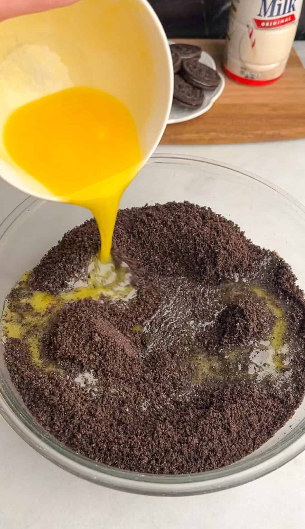 adding melted butter to oreo crumbs