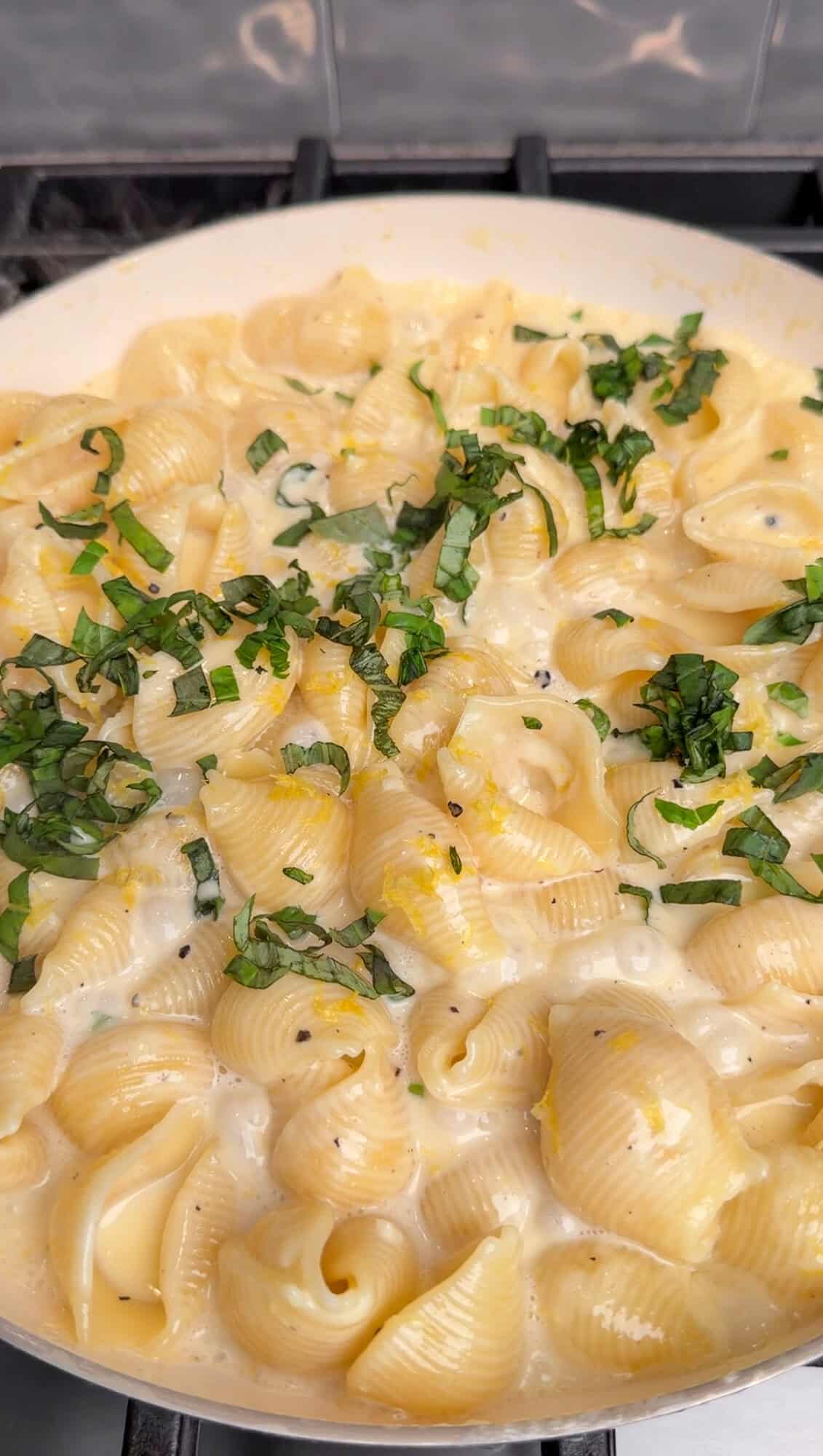 Topping pasta al limone with basil and lemon zest