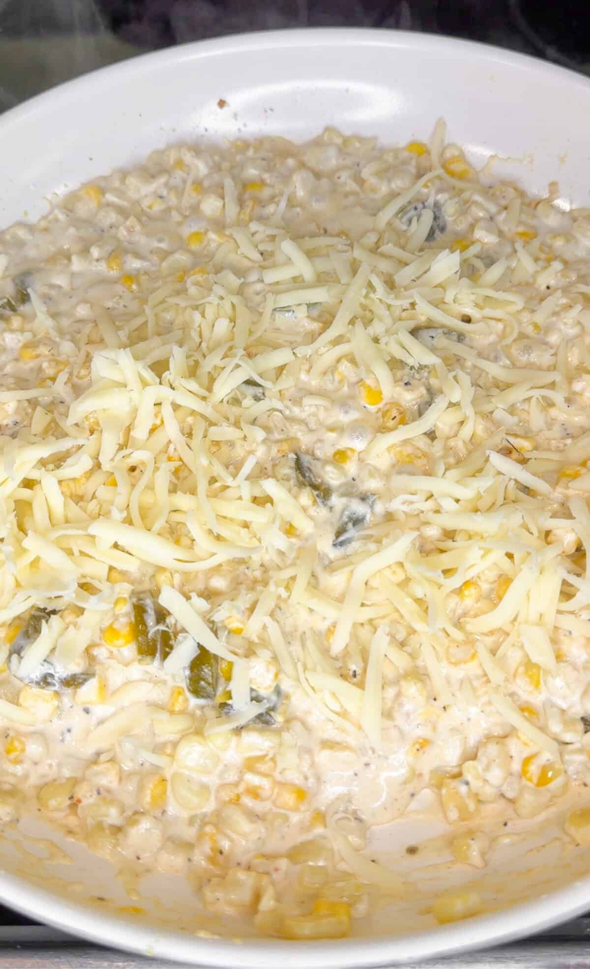 folding in cheese to hot corn dip