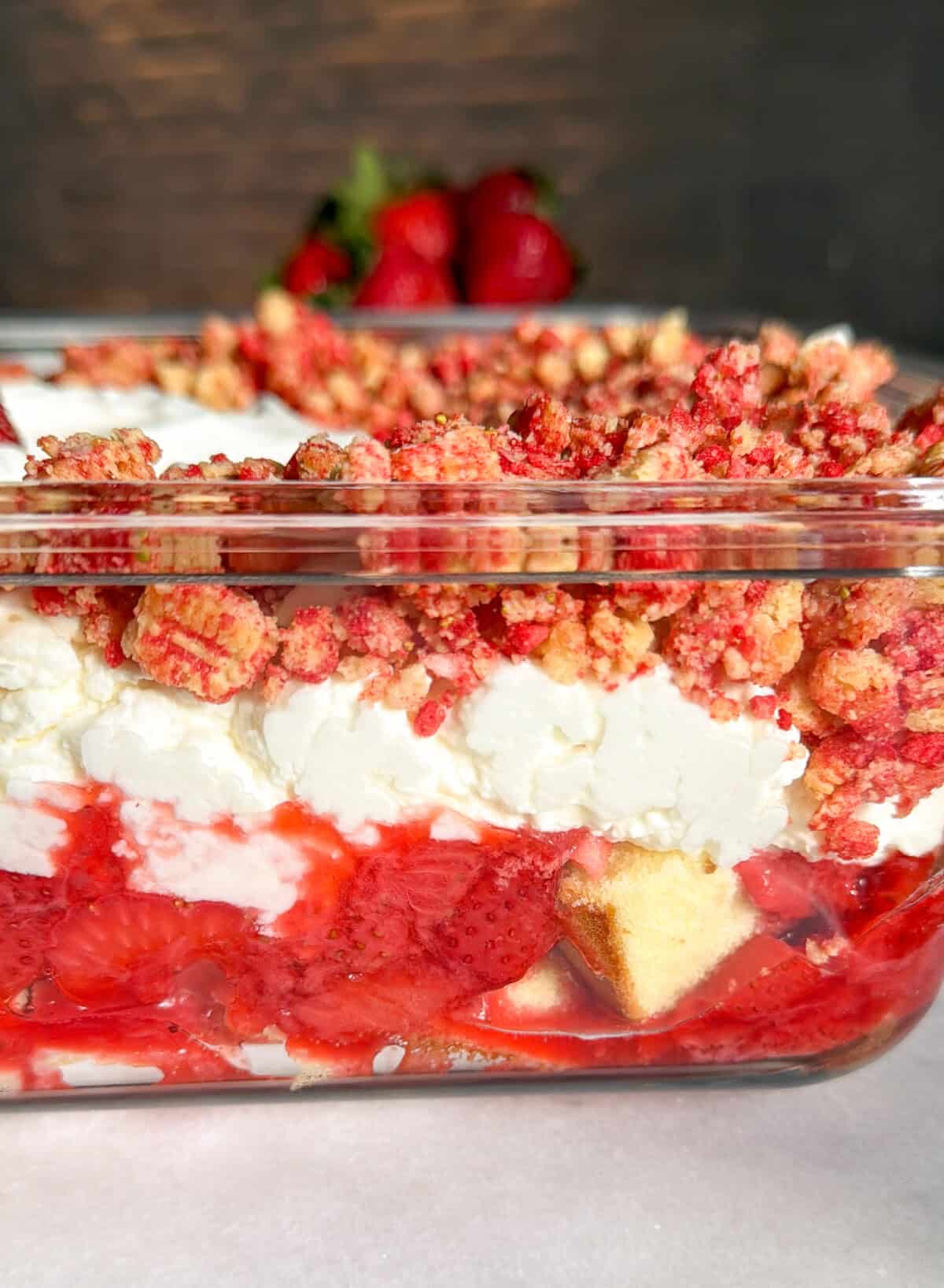 side view of strawberry shortcake cheesecake delight in a glass 9x13 pan