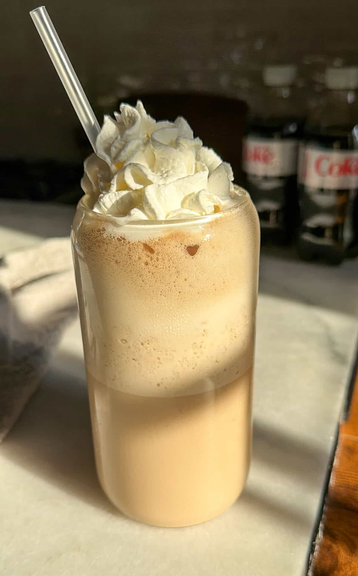 whipped diet coke in a glass with whipped cream and cherry