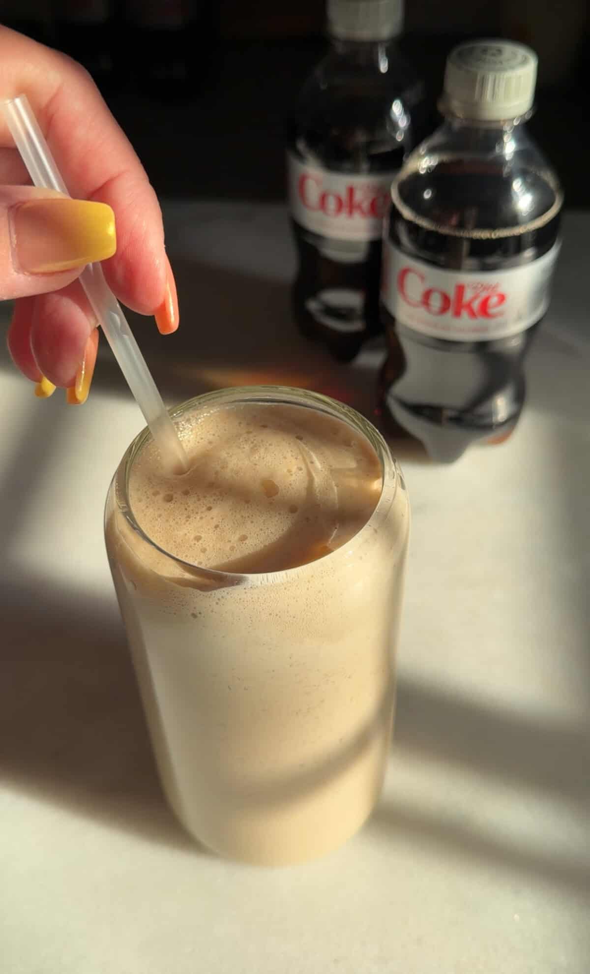whipped diet coke in a glass with a straw