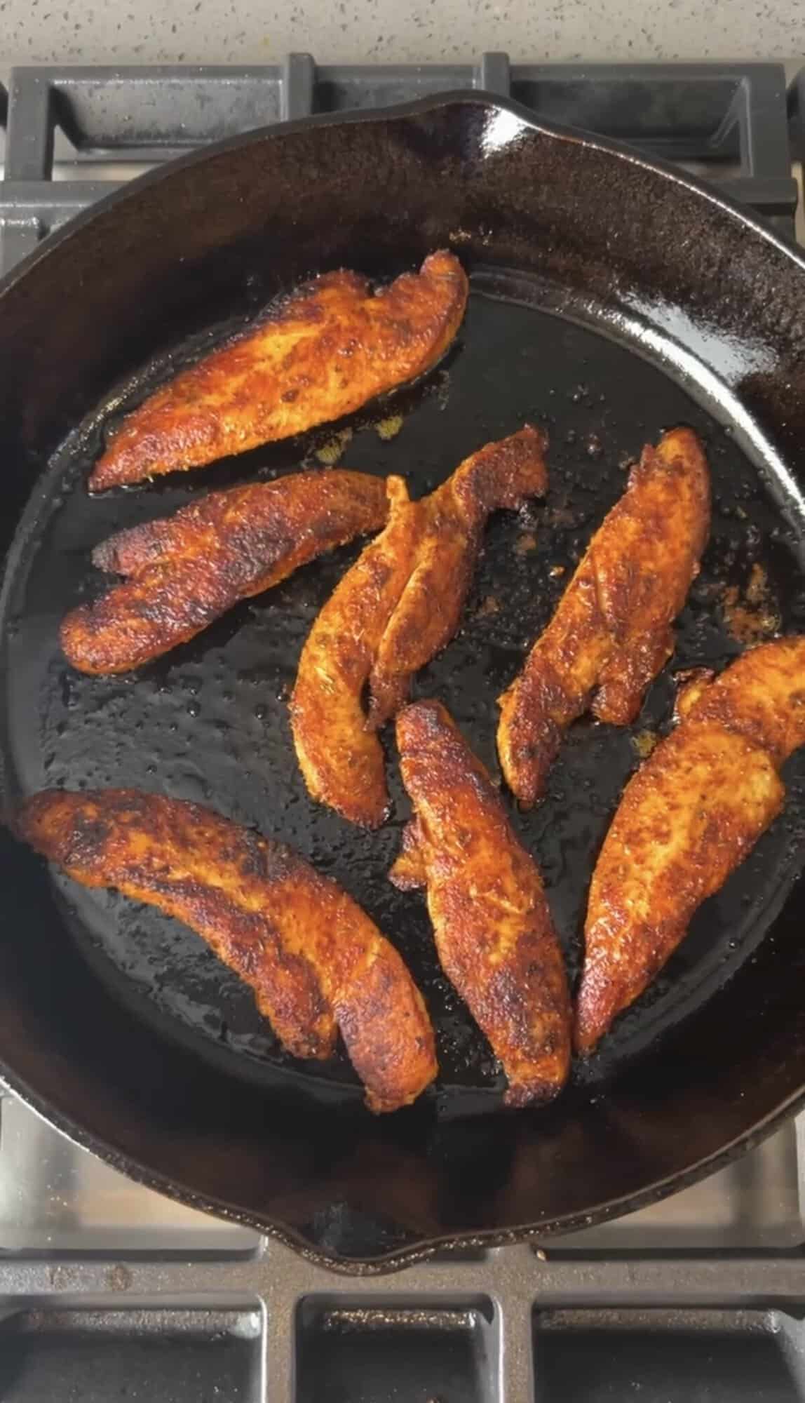 chicken tenderloins cooking in a pan