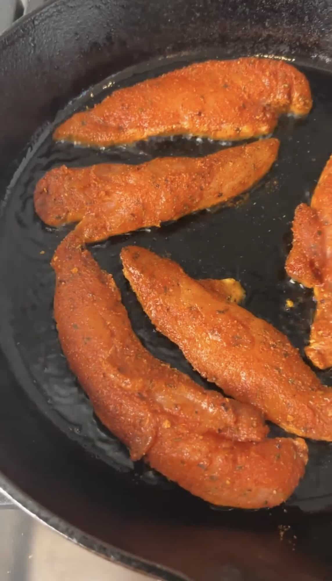 chicken tenderloins cooking in a pan