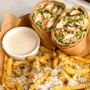 chicken caesar wrap on a plate with garlic parm fries