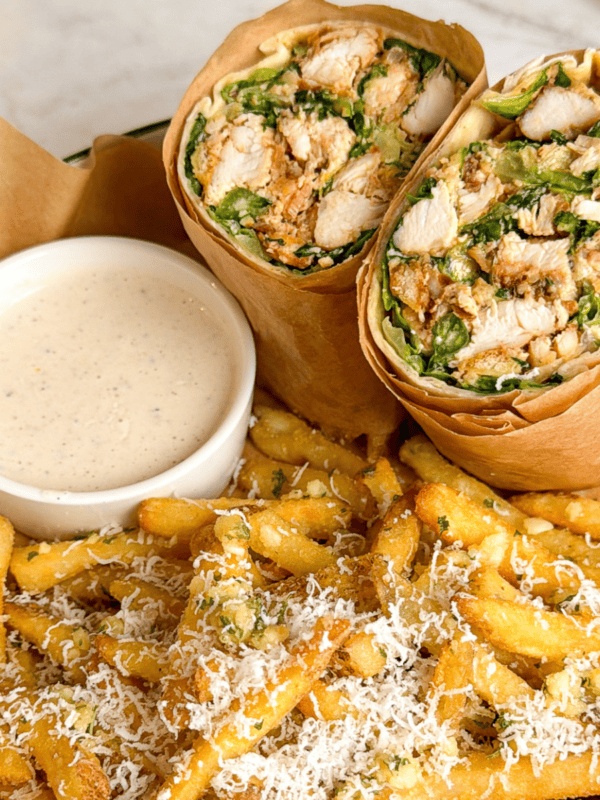 chicken caesar wrap on a plate with garlic parm fries