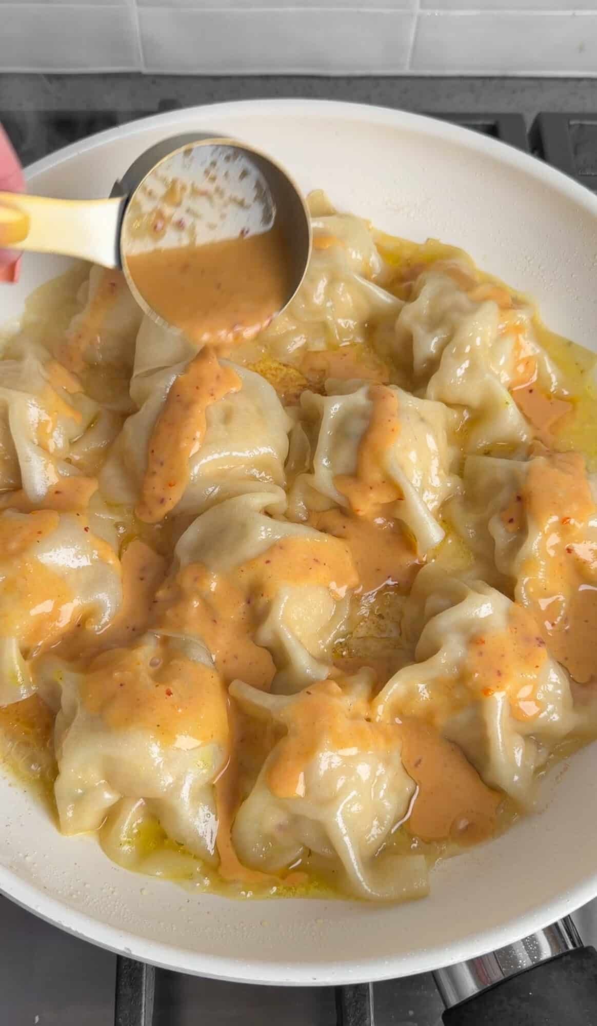 adding Thai peanut sauce to blanket dumplings