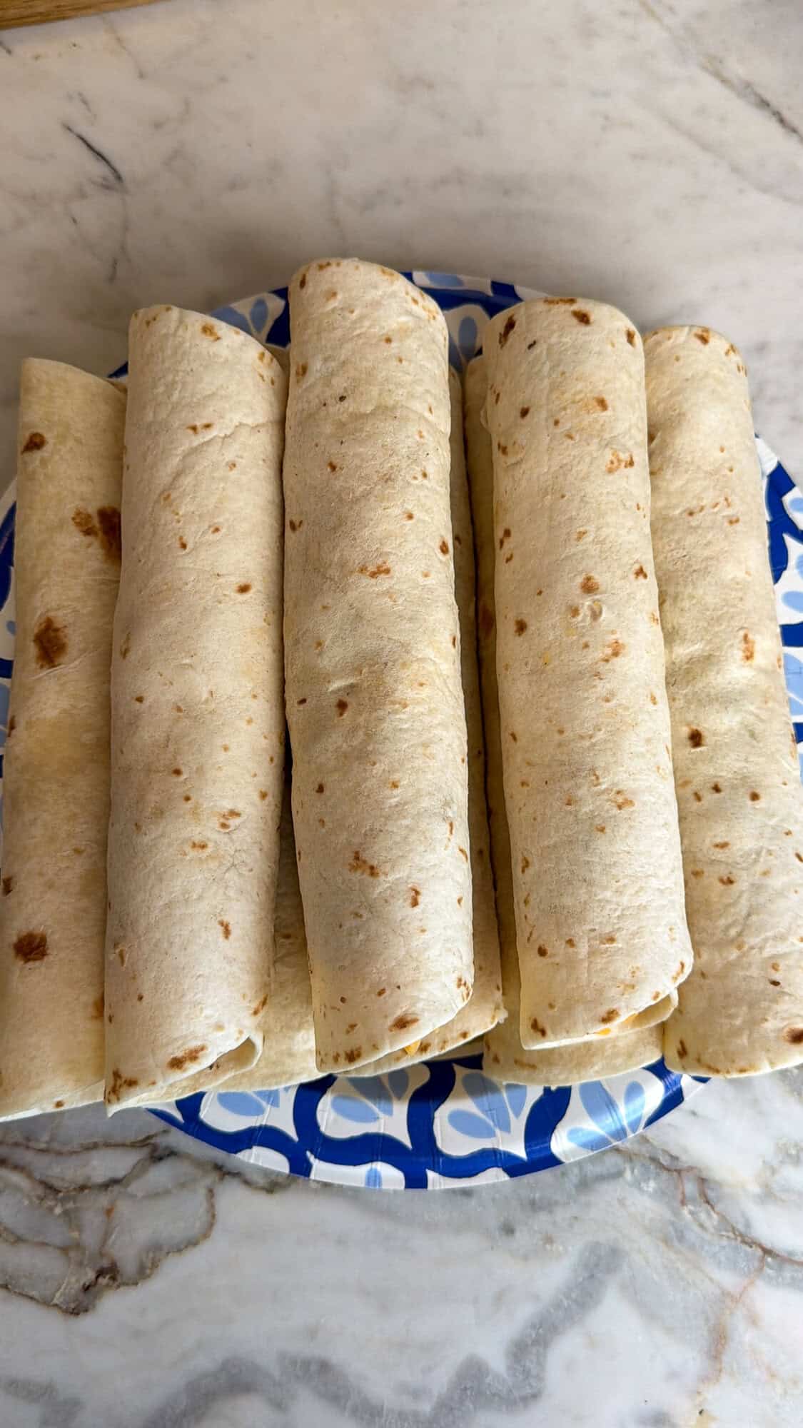 rolled cheeseburger taquitos on a plate
