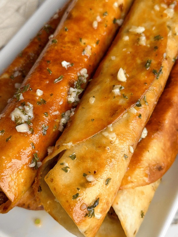 taquitos on a plate brushed with garlic butter