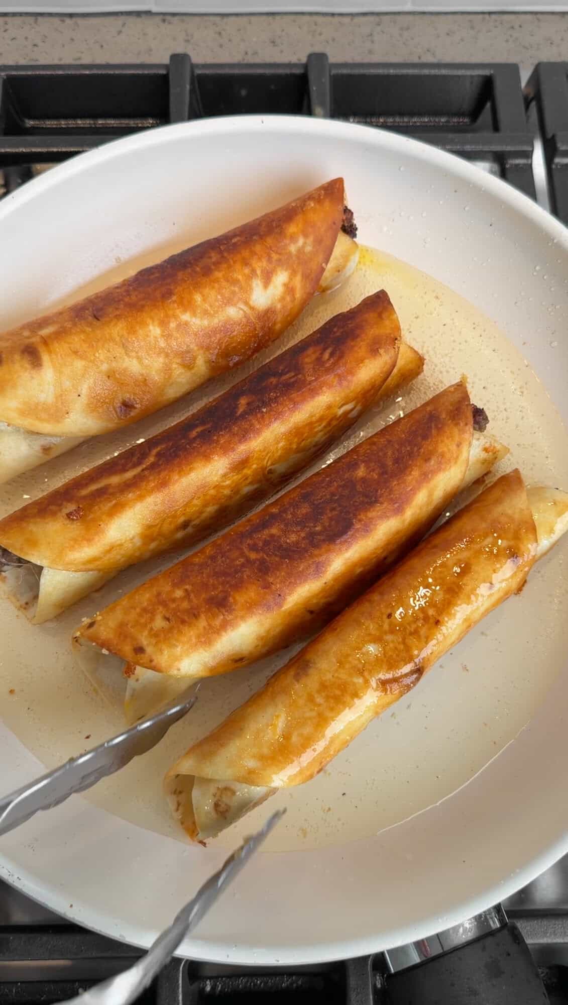 taquitos frying in a pan