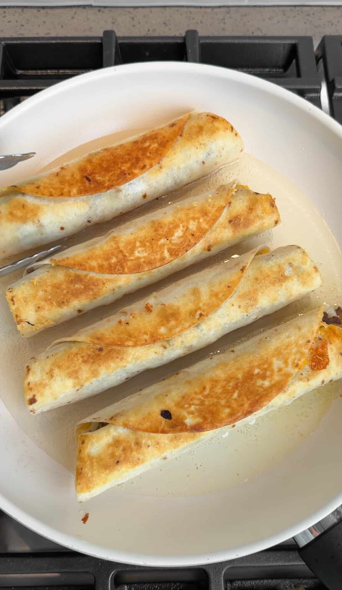 pan frying taquitos in a pan