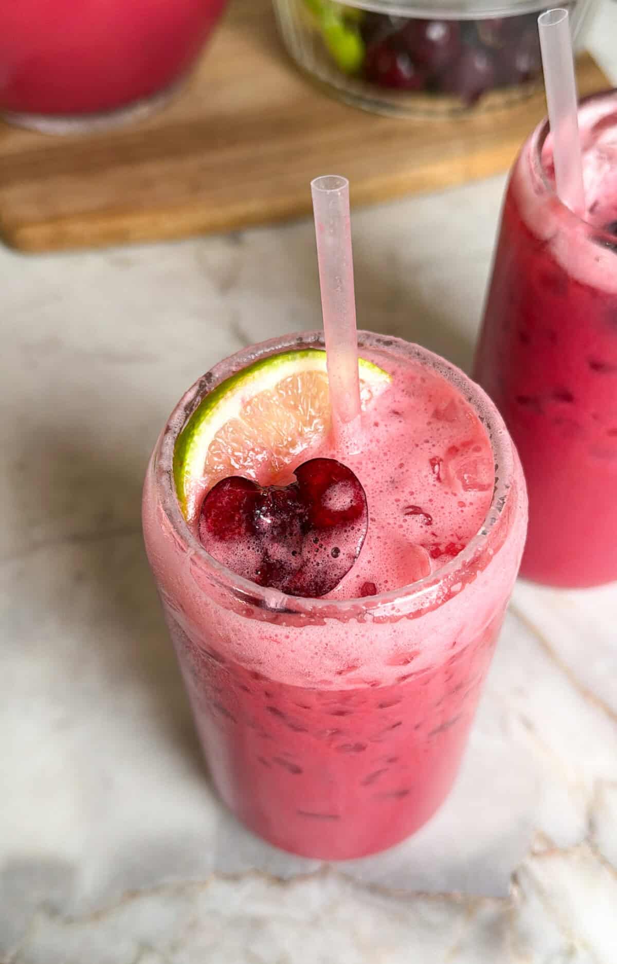 creamy cherry limeade with cherries and lime wedge on top