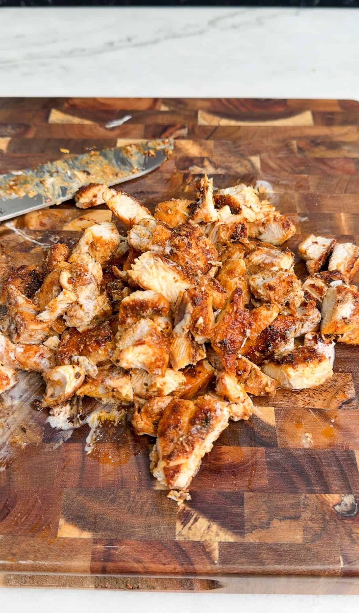chopping chicken on a cutting board