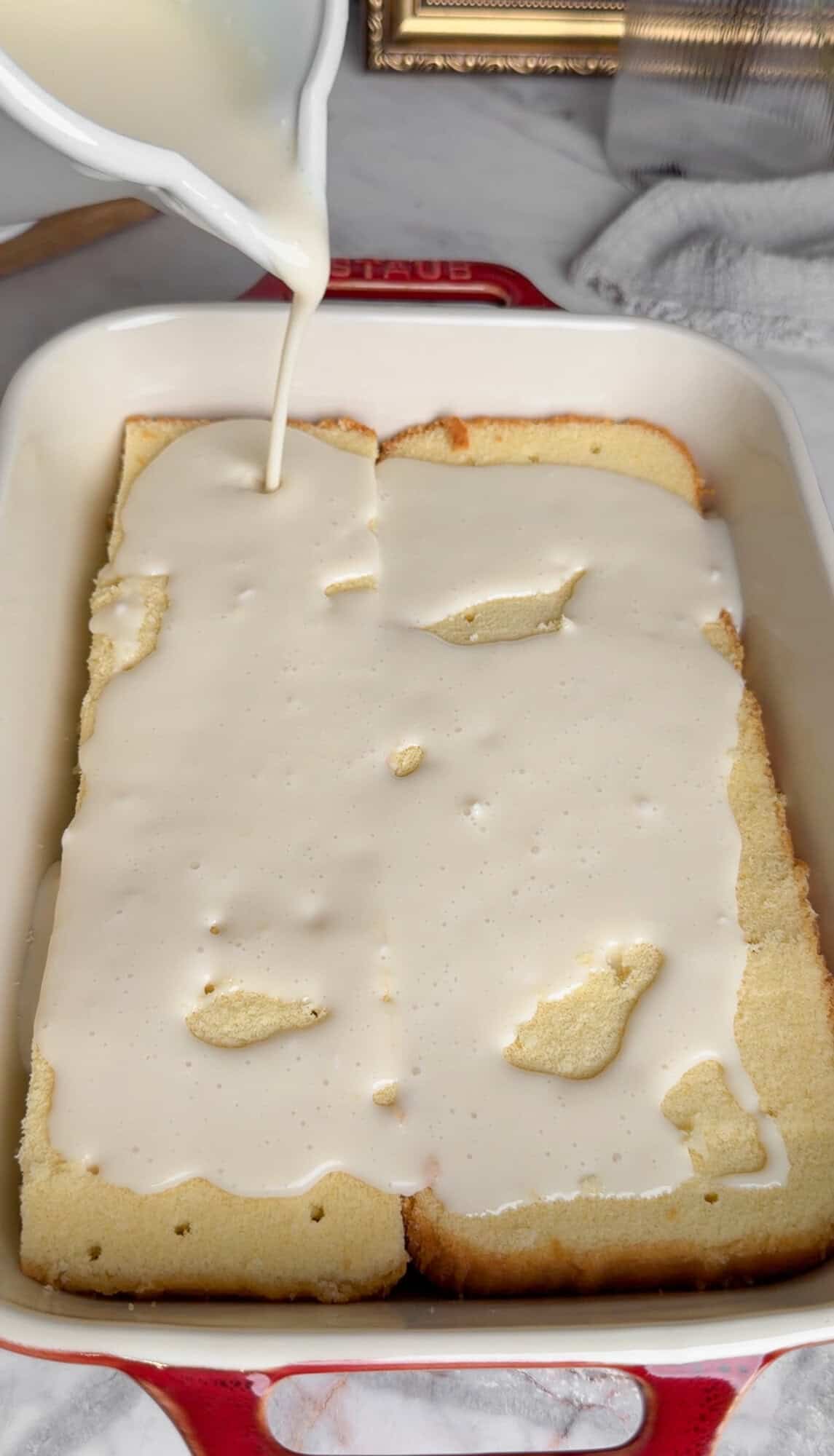 adding the milk soak to coconut cake