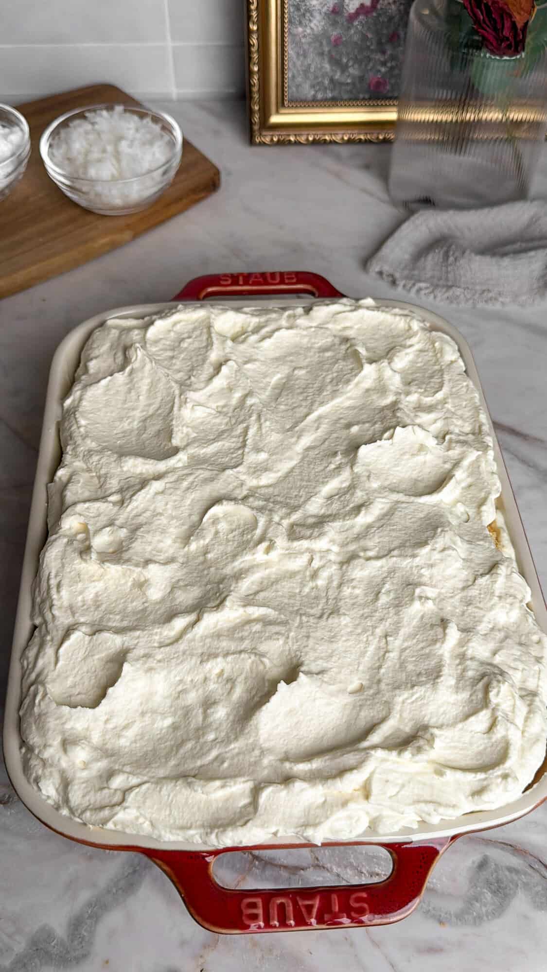 topping coconut cake with whipped crea
