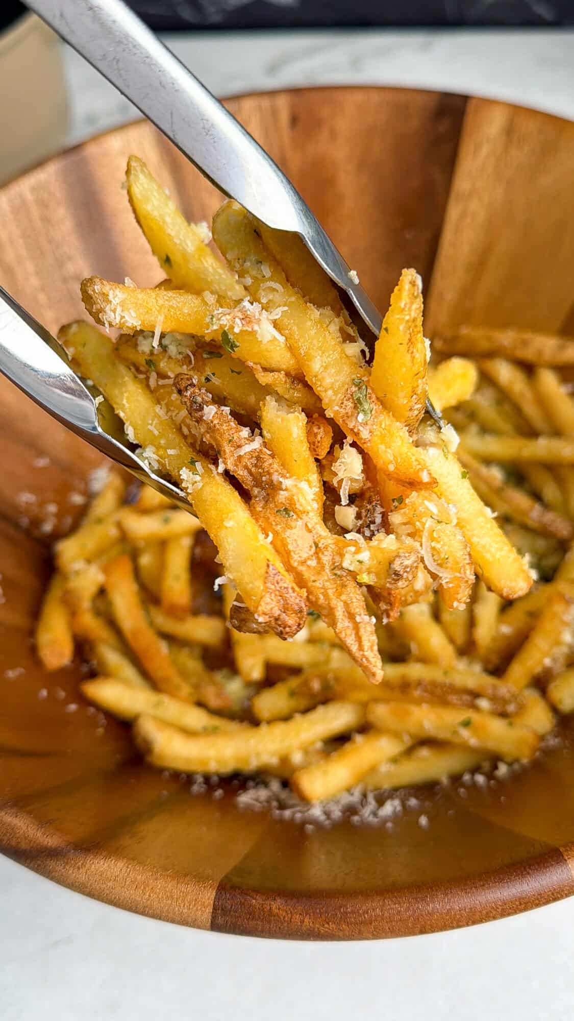 tossing fries in garlic butter and parmesan