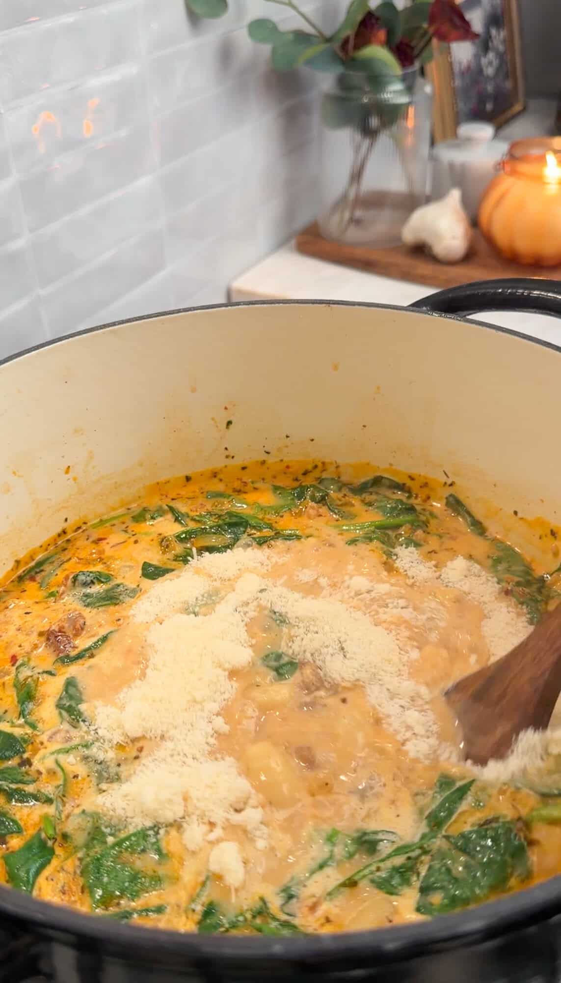 adding parmesan to sausage gnocchi soup