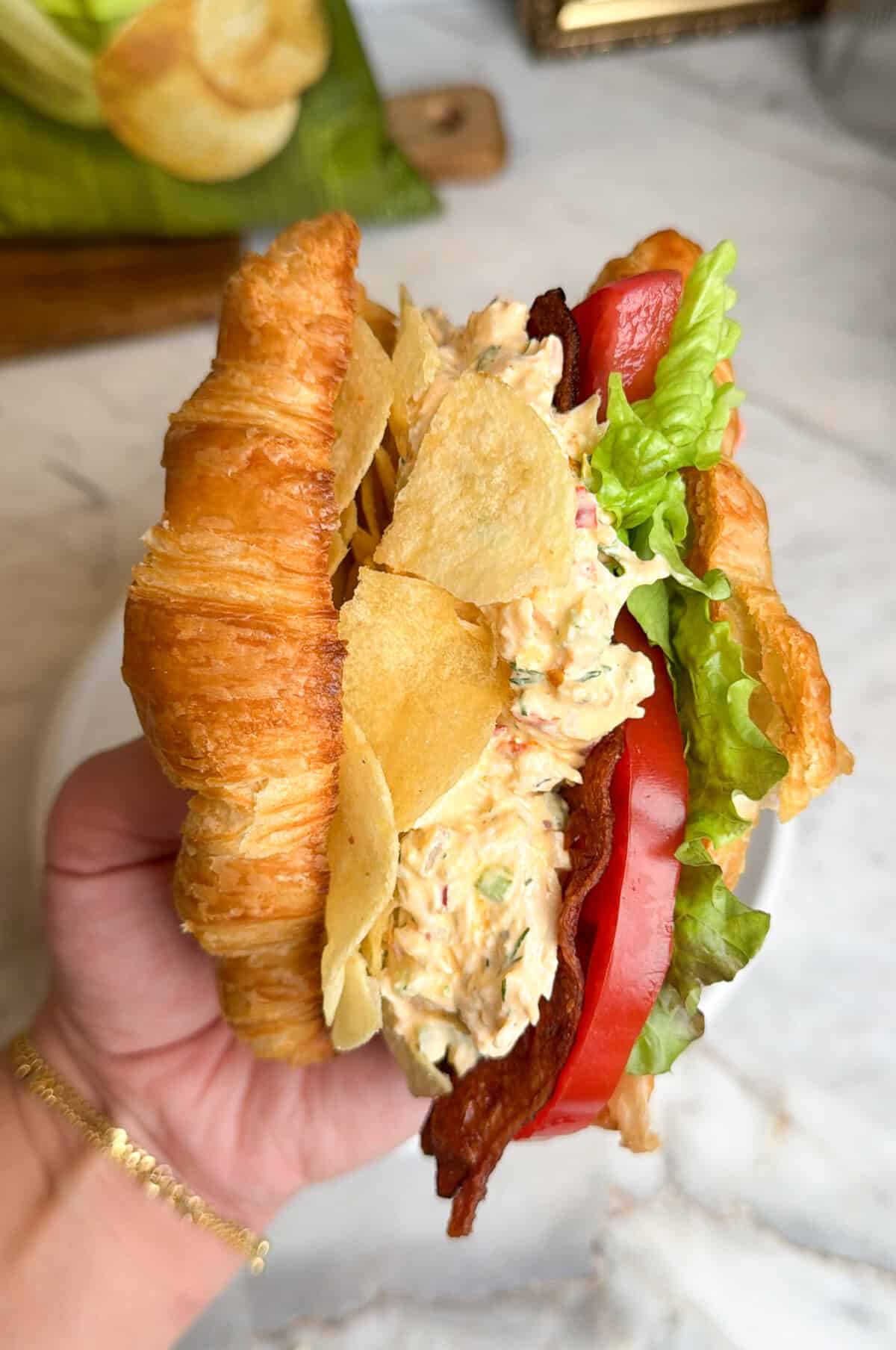 pepperoncini chicken salad sandwich being held in hand