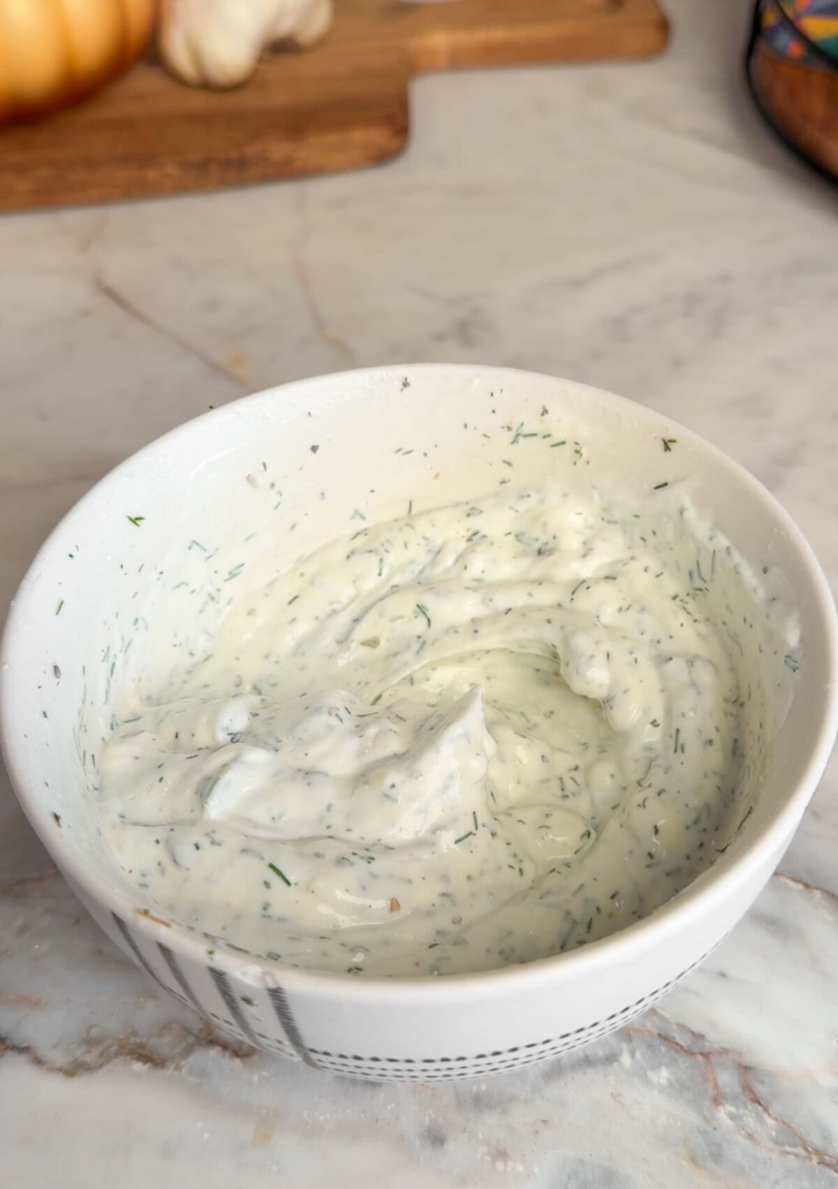 An easy Greek chicken rice bowl with juicy air-fryer chicken skewers, fresh tomato-cucumber salad and creamy garlic-dill yogurt sauce. Greek yogurt, mayo, fresh dill, garlic, lemon juice, salt, and pepper mixed together in a bowl.