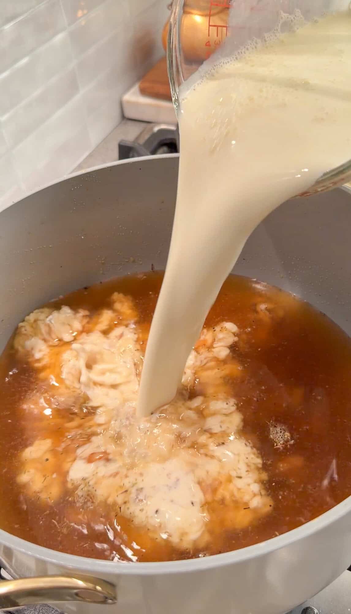adding chicken stock and cream to chicken alfredo soup
