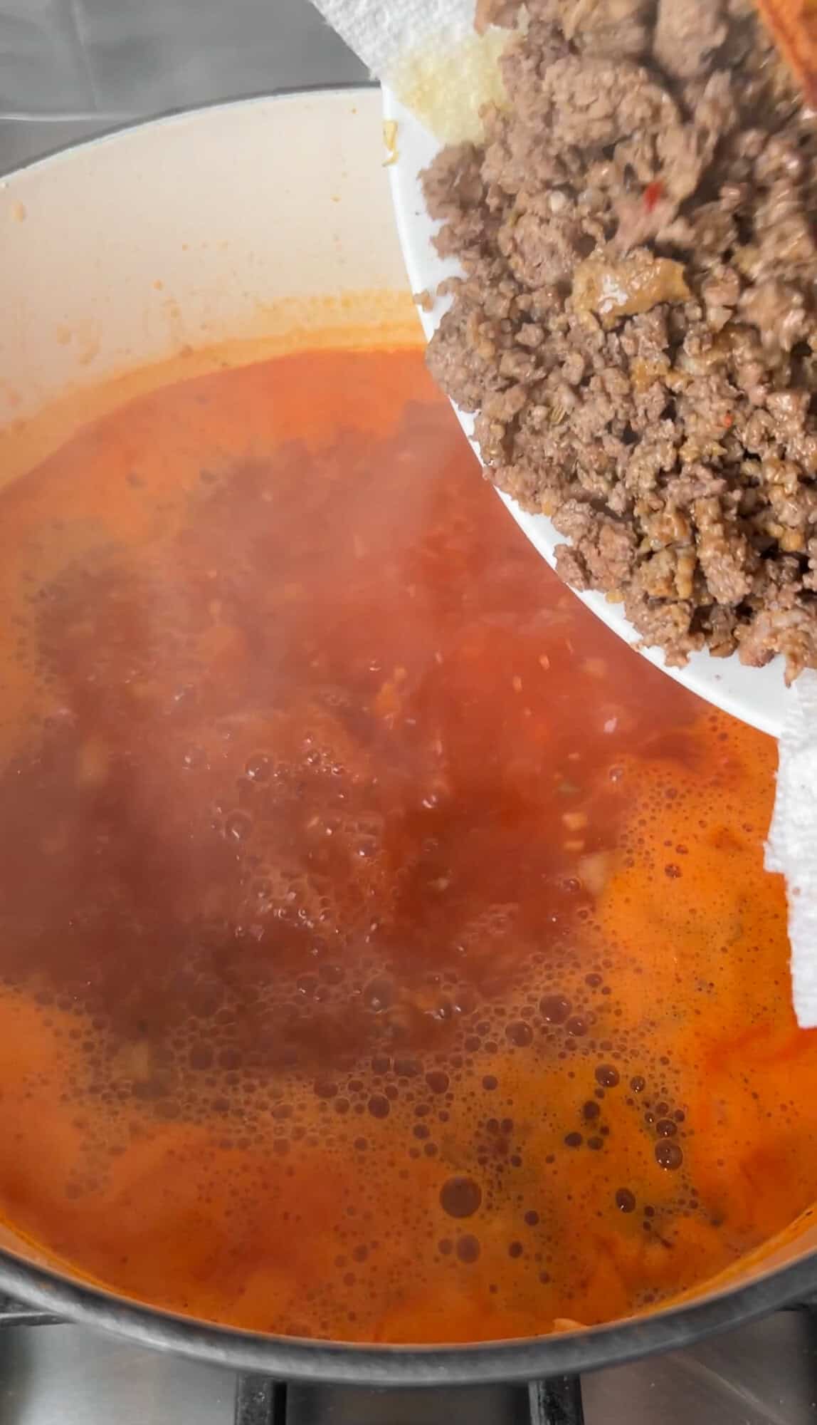 adding the beef and sausage into lasagna soup