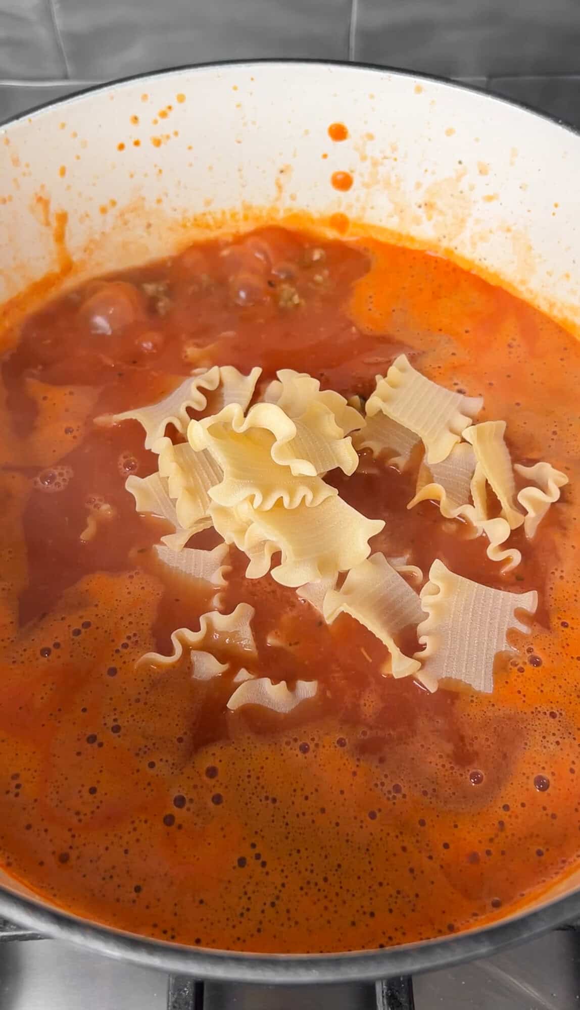 putting the pasta into the boiling soup