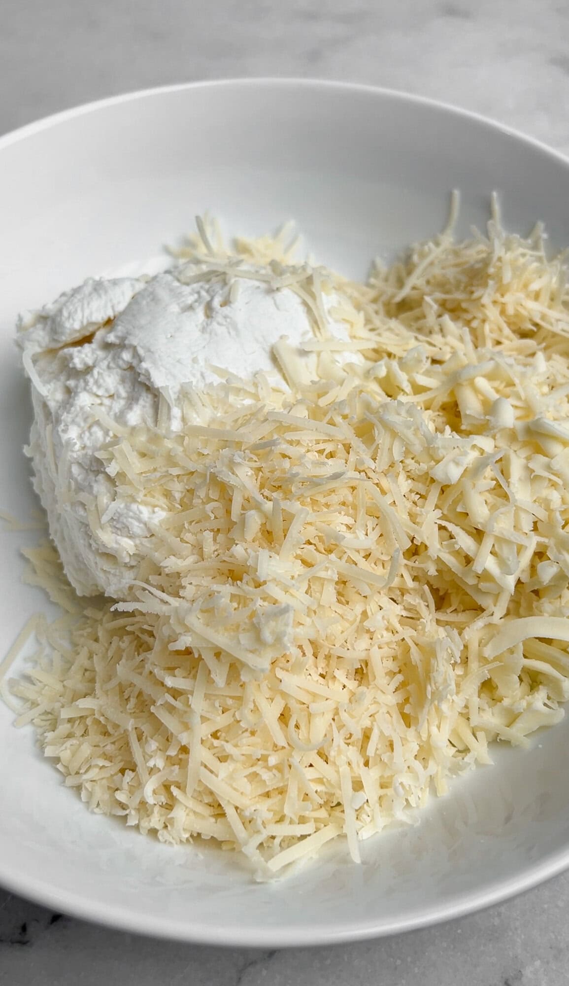 ricotta, parmesan, and mozzarella with seasonings in a bowl