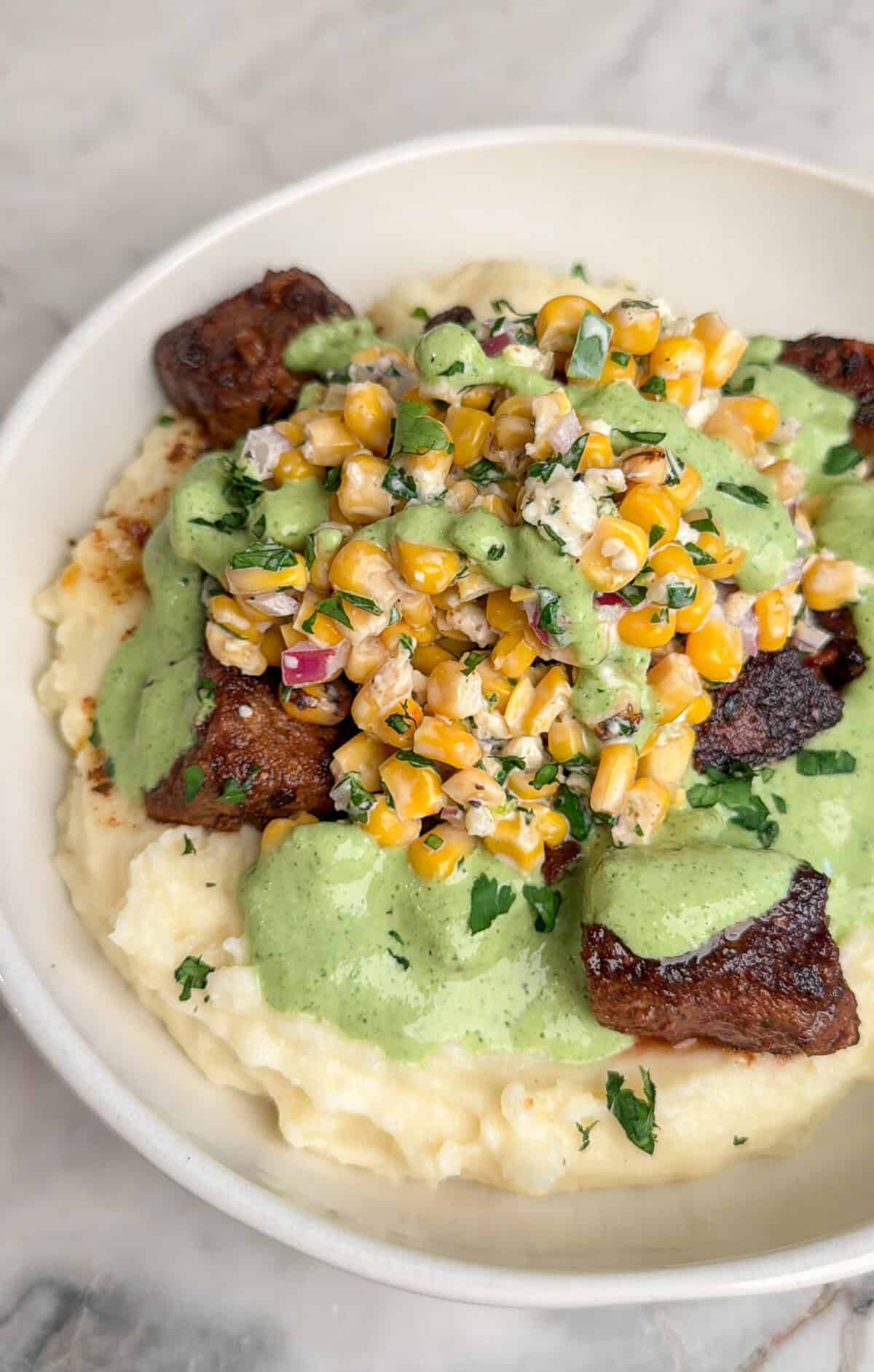 steak bowls topped with street corn and aji verde