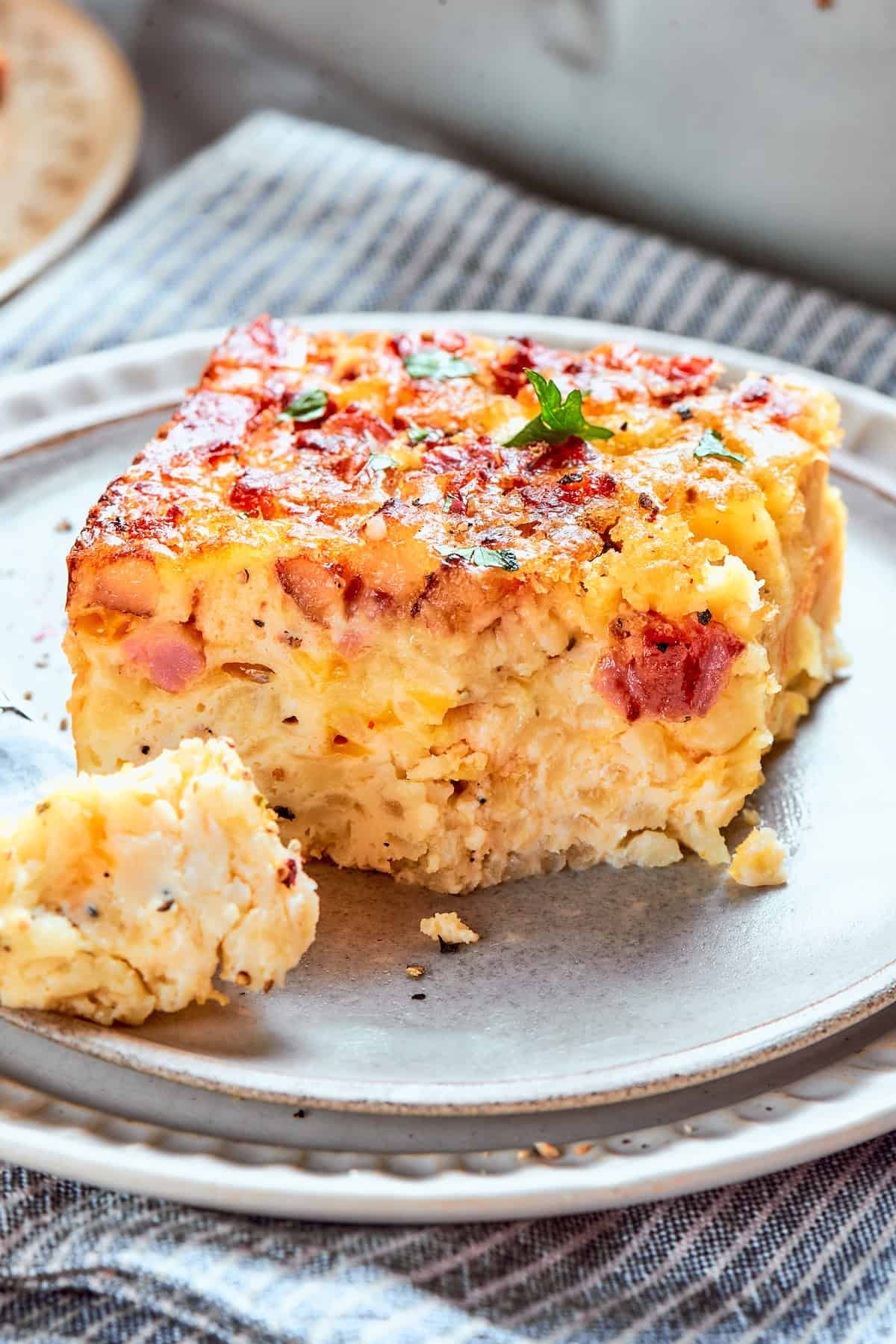 Loaded with bacon, eggs, and cheese and baked in one dish, this hashbrown breakfast casserole is the easiest way to do brunch for a crowd. A slice of hashbrown breakfast casserole on a plate.