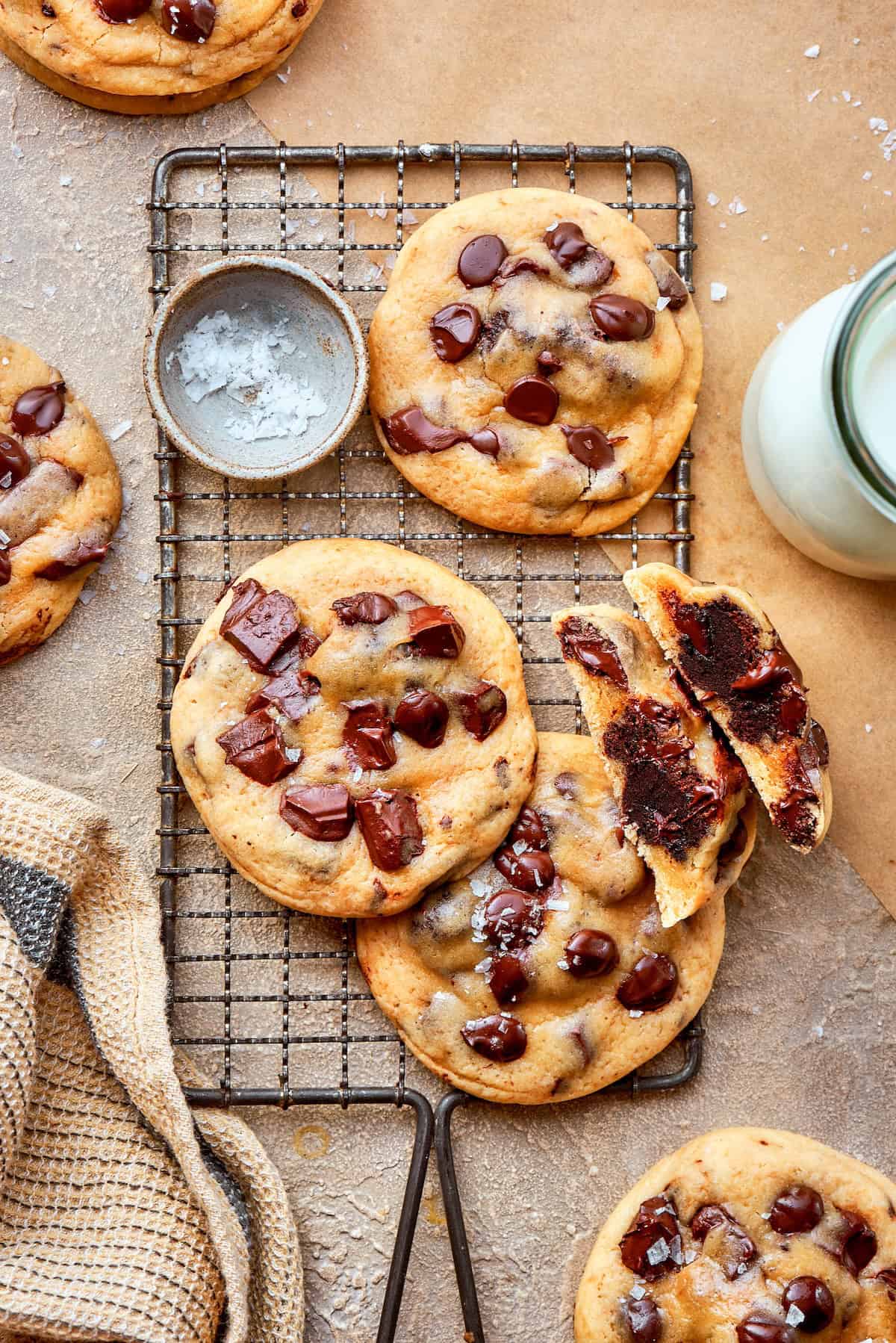 Double dessert? Yes! These brownie-stuffed cookies wrap gooey brownie bites in chewy, golden-brown chocolate chip cookies. Overhead image of 3 whole stuffed chocolate chip cookies with another cut in half to reveal the inside.