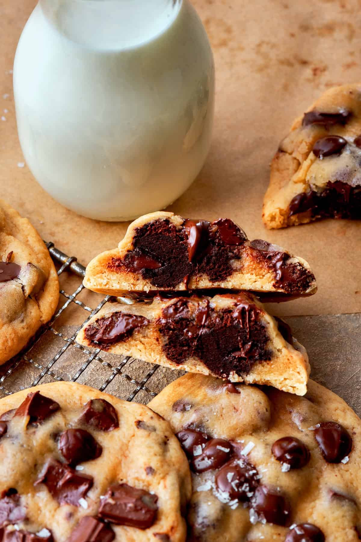 Double dessert? Yes! These brownie-stuffed cookies wrap gooey brownie bites in chewy, golden-brown chocolate chip cookies. A halved stuffed cookie revealing the brownie inside.