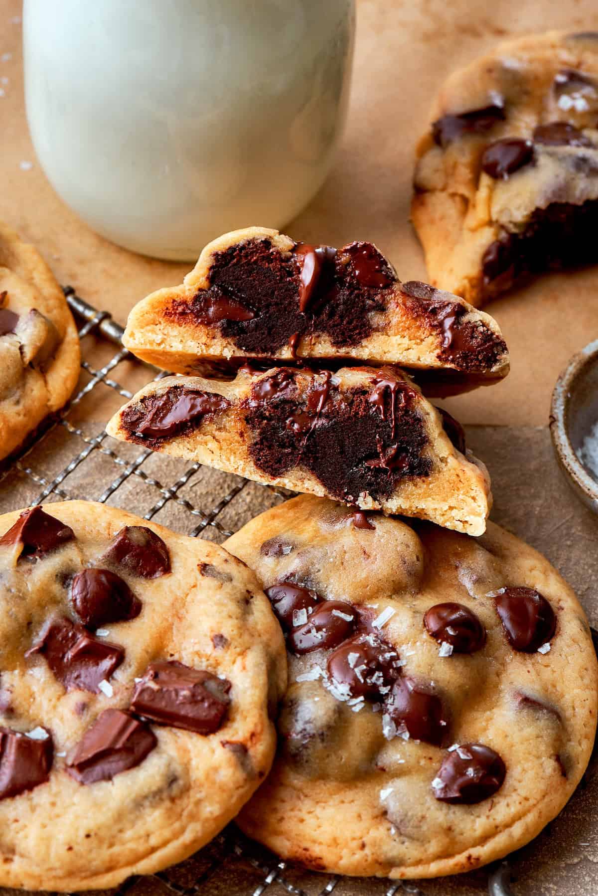 A halved brownie-stuffed chocolate chip cookie stacked on whole cookies.