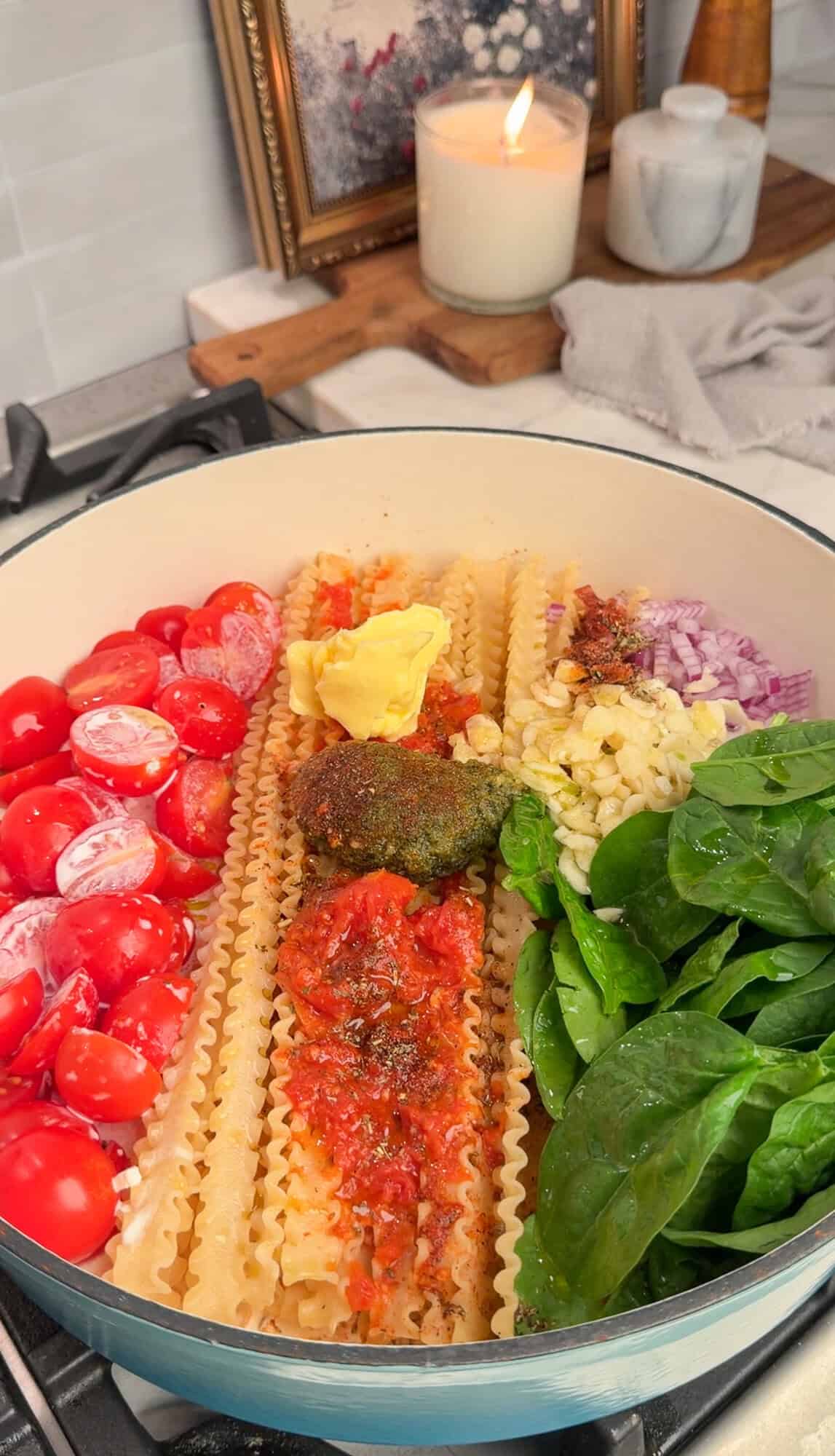 adding all the ingredients into a pot for creamy tomato pasta