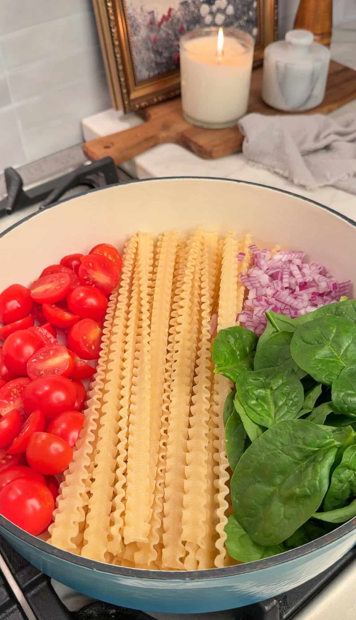 adding all the ingredients into a pot for creamy tomato pasta