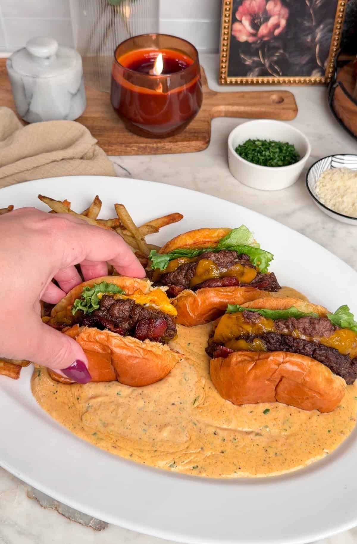 adding sliced burgers face-down into the garlic parmesan sauce