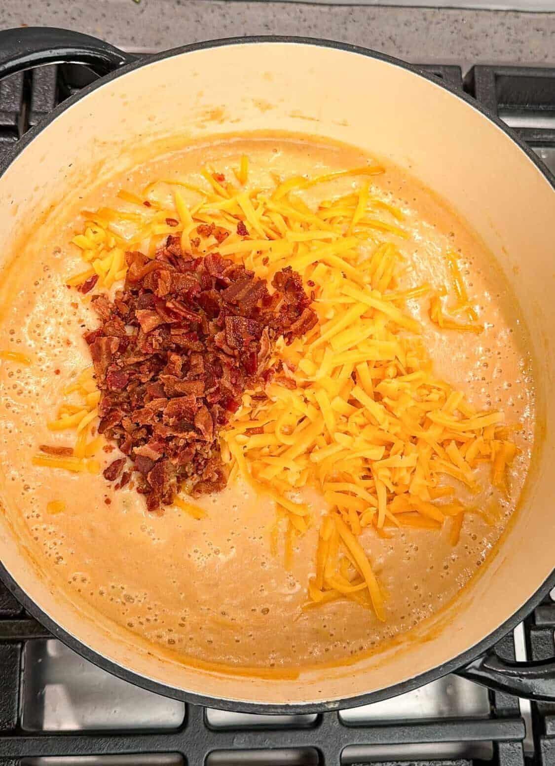 adding cheese and bacon to loaded baked potato soup