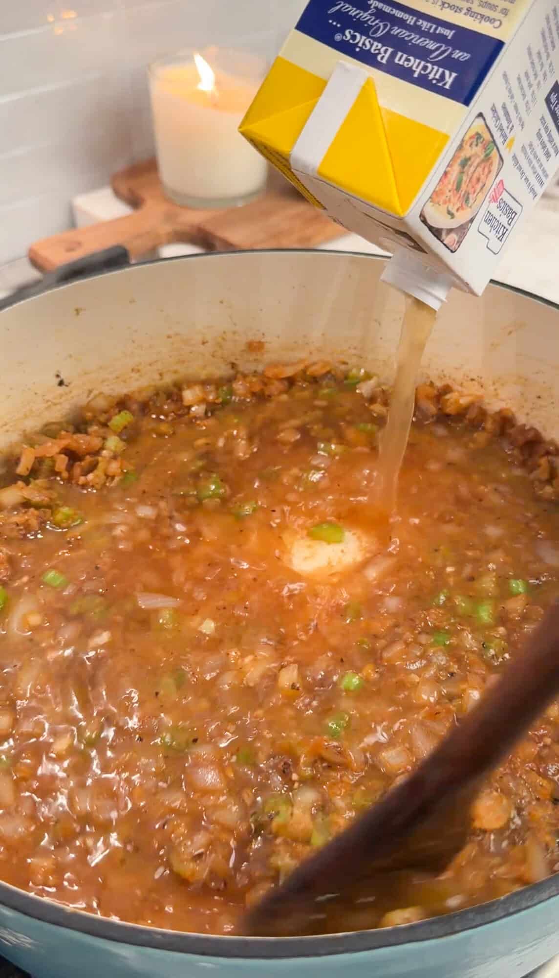 adding chicken stock into chicken gnocchi soup